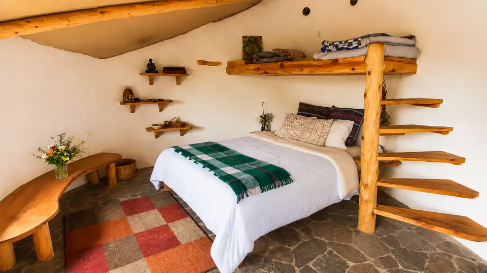 Hobbit House: bedroom with branch ladder up to the loft.