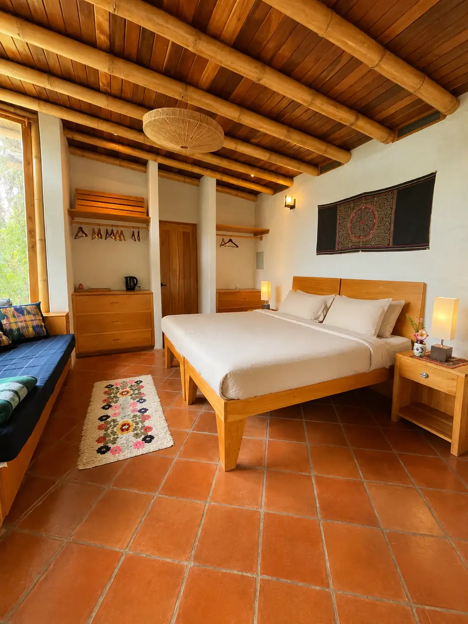 Casita: bedroom: bed, tile floor, daybed and textile wall hanging.