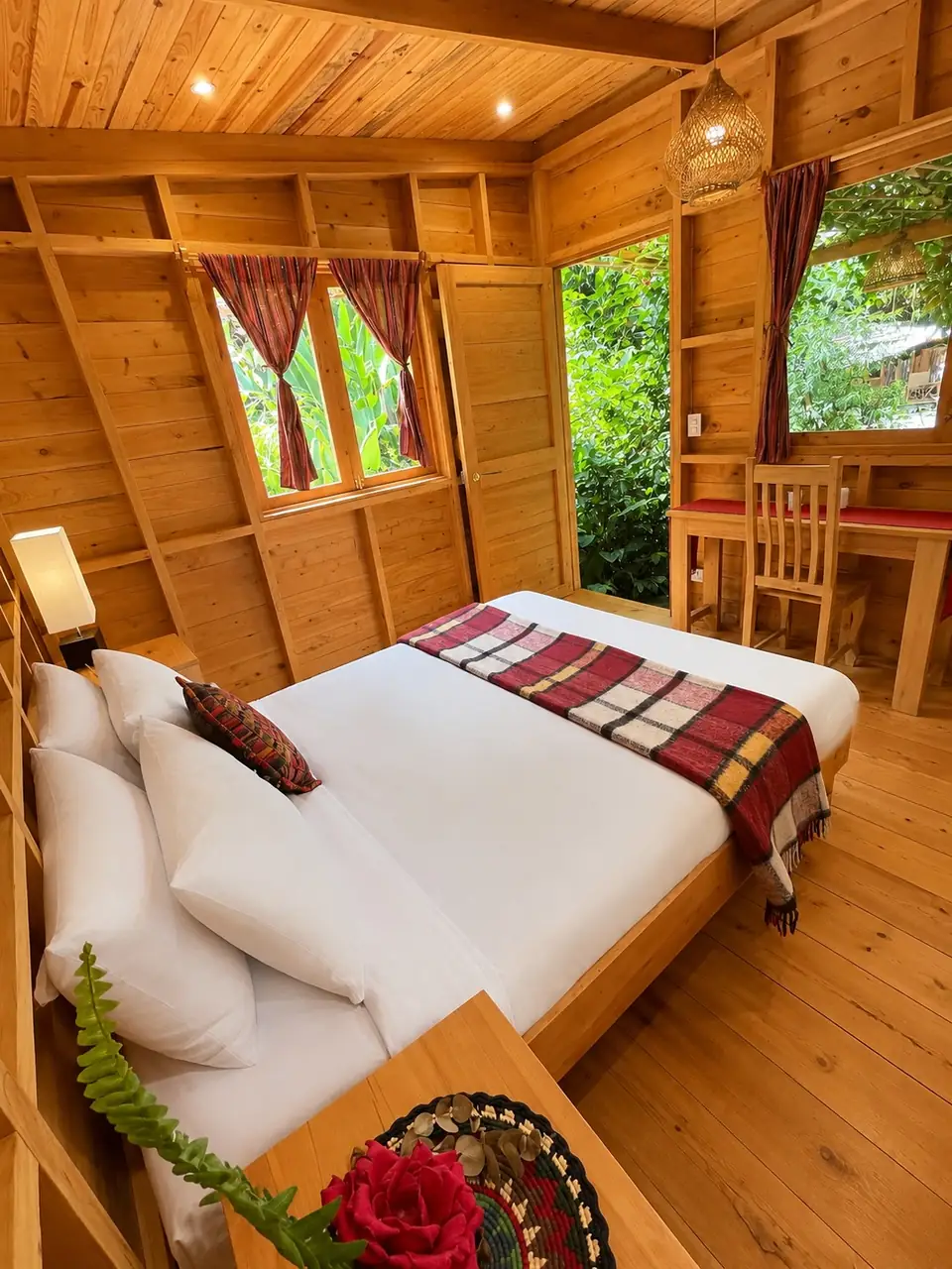 Garden Cabin: queen bed close-up with red throw.
