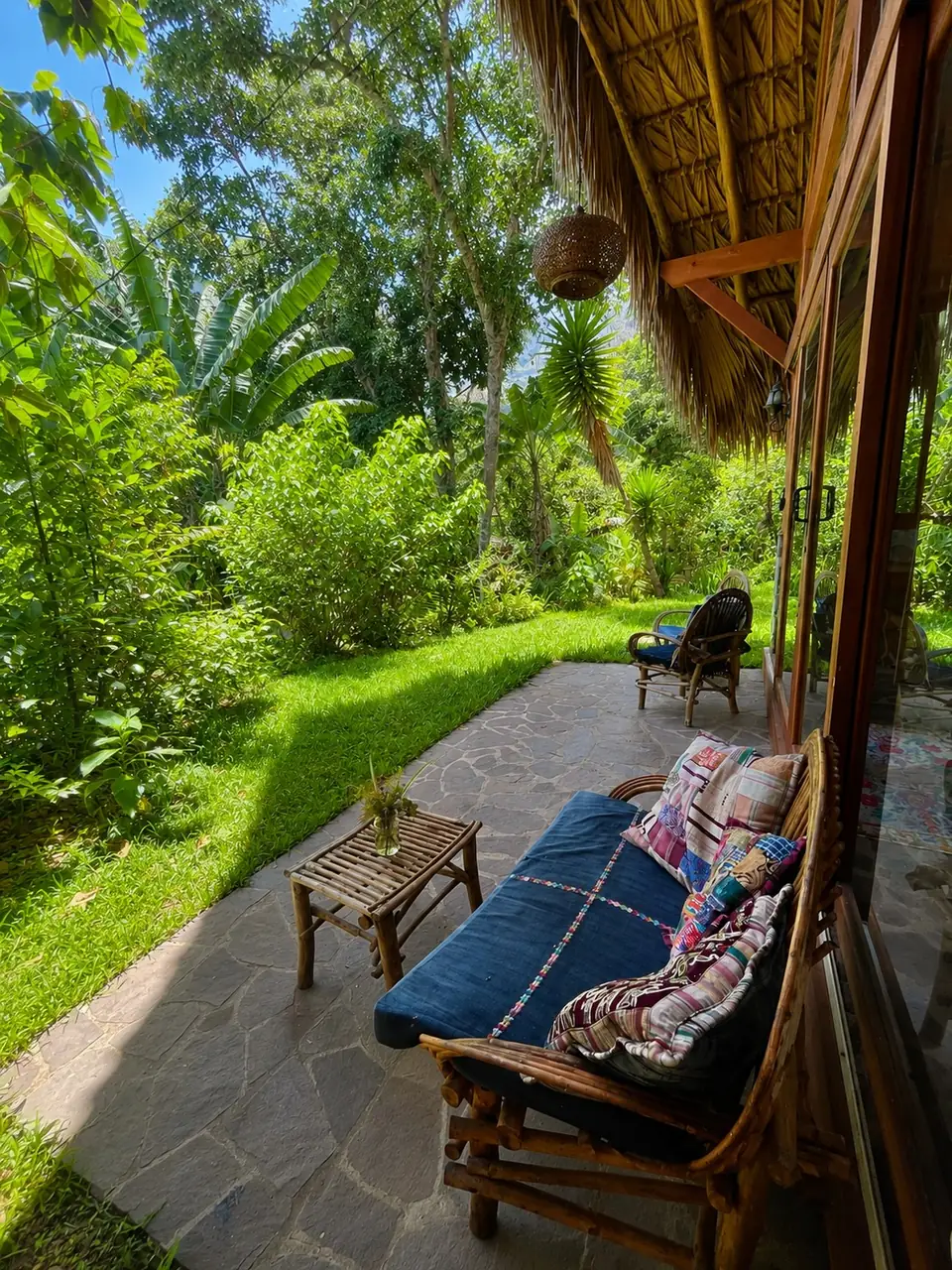 Kiya: terrace with lounge couch, lawn and garden.