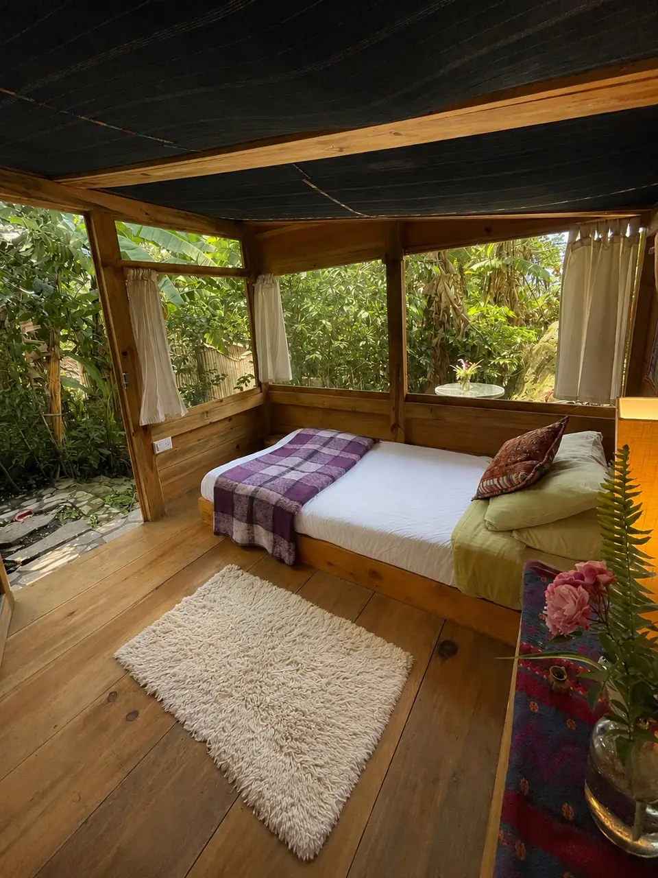 Tambo: single bed, screened windows, sheepskin rug.